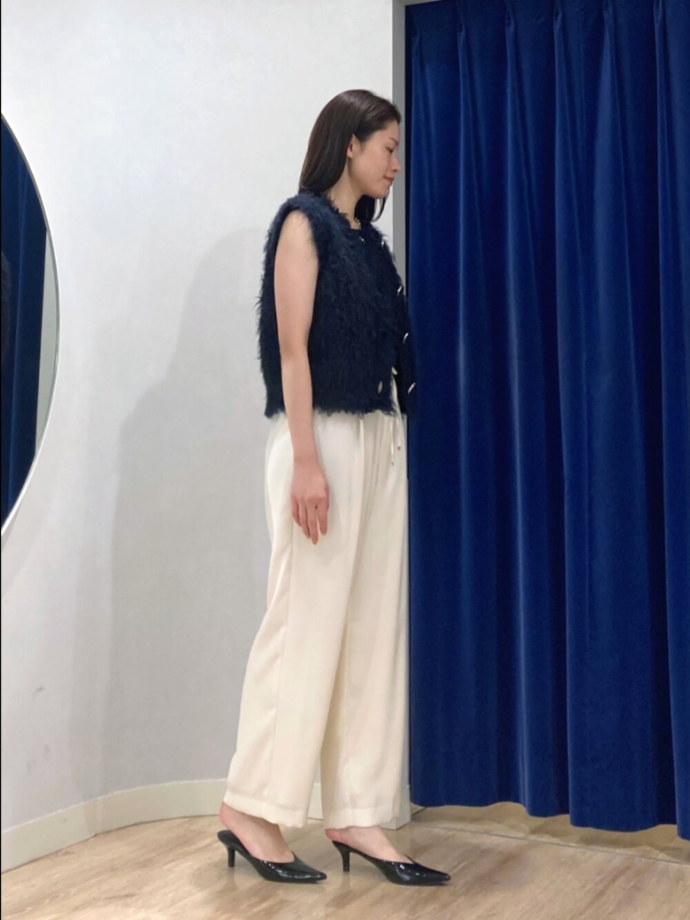 ブルー系のベスト、ブラック系のタンクトップ、ブラウン系のその他パンツを着用したレディースの秋コーディネートの4枚目の写真