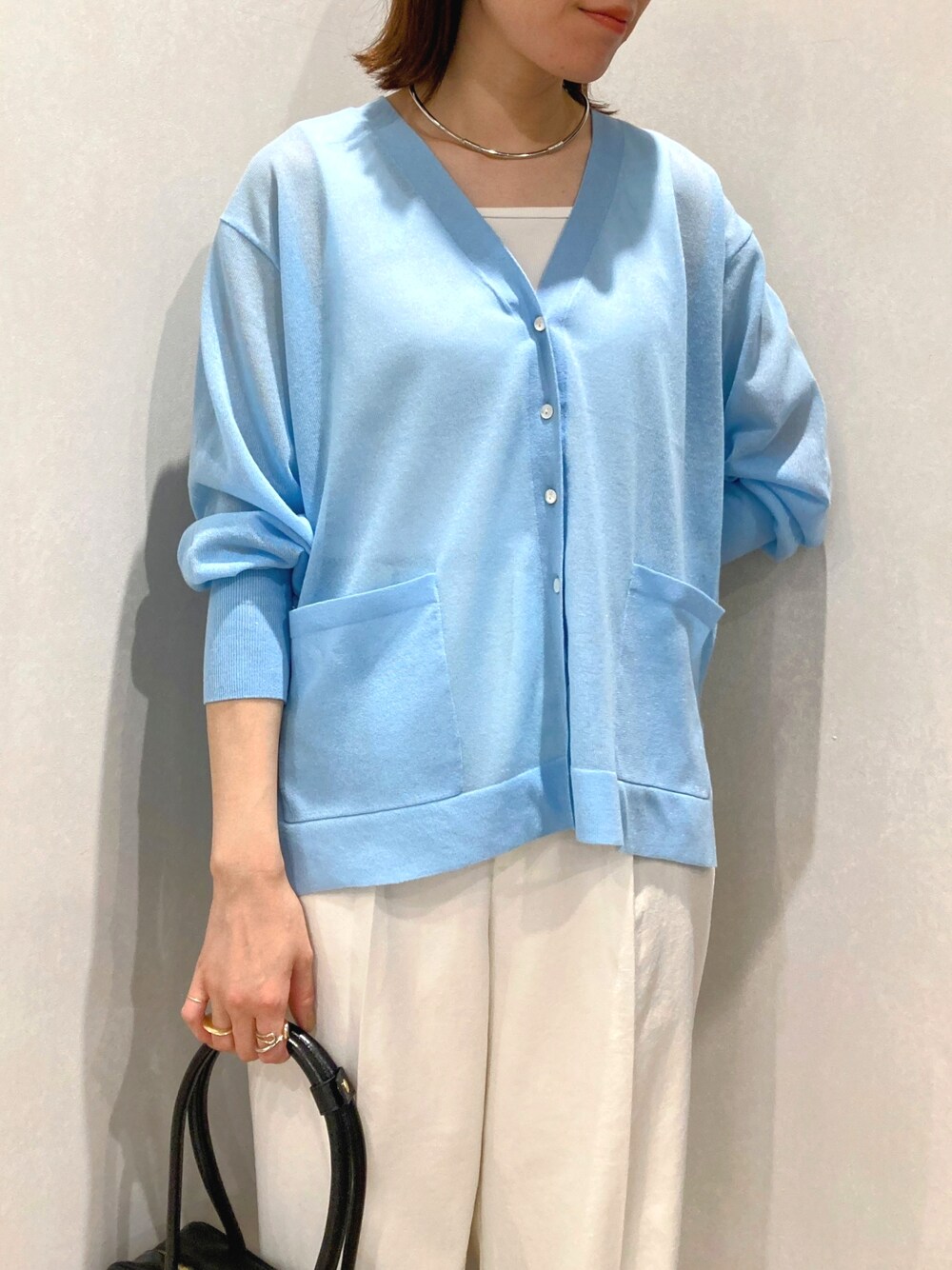 ブルー系のカーディガン/ボレロ、ホワイト系のタンクトップ、ブラック系のボストンバッグを着用したレディースの夏コーディネートの6枚目の写真