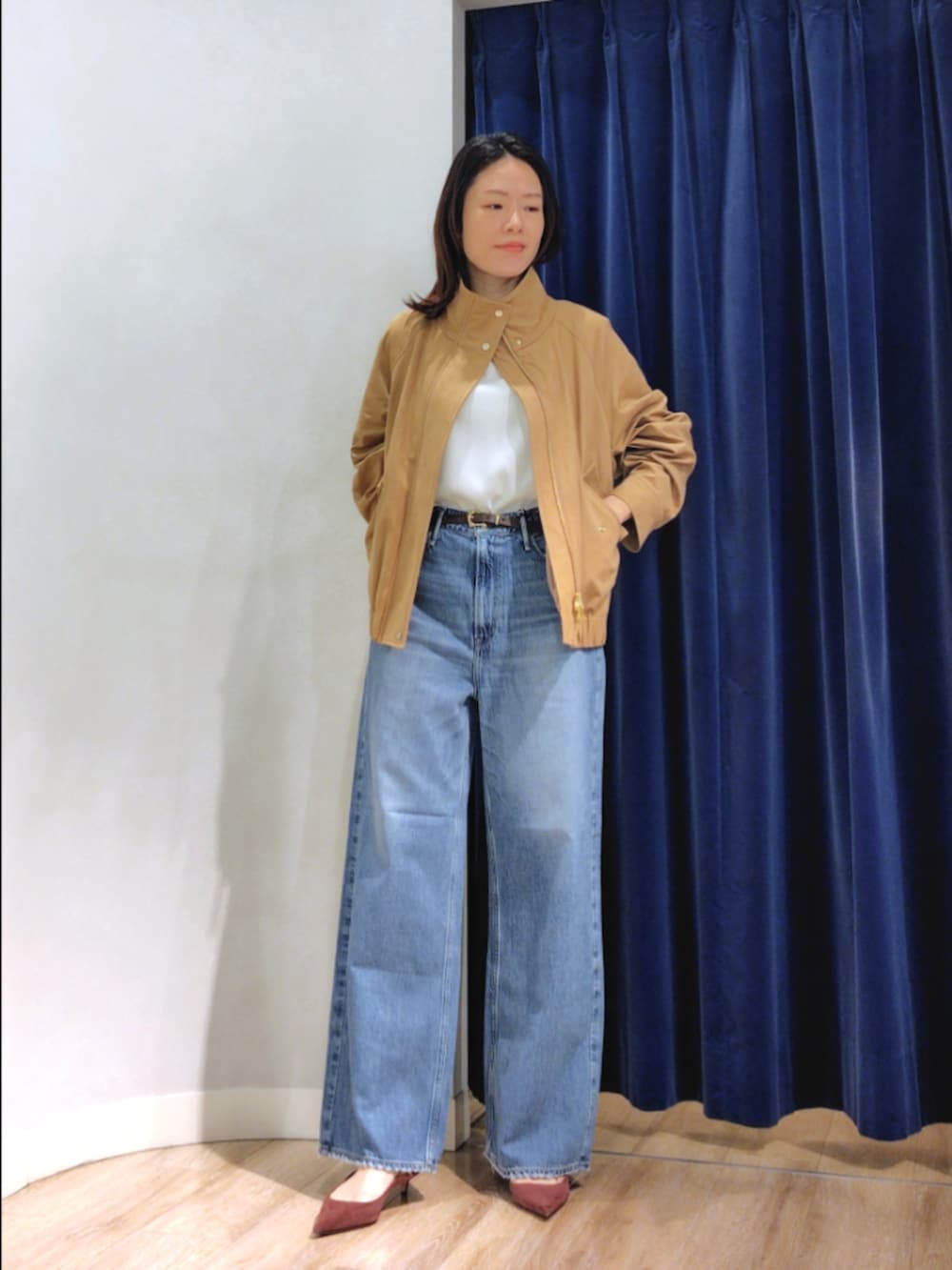 ブルー系のシャツ/ブラウス、イエロー系のブルゾン、ブルー系のデニムパンツを着用したレディースの秋コーディネートの3枚目の写真
