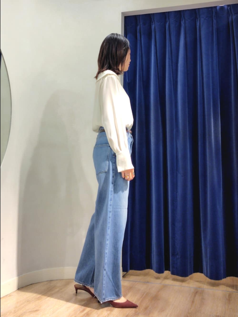 ブルー系のシャツ/ブラウス、イエロー系のブルゾン、ブルー系のデニムパンツを着用したレディースの秋コーディネートの3枚目の写真