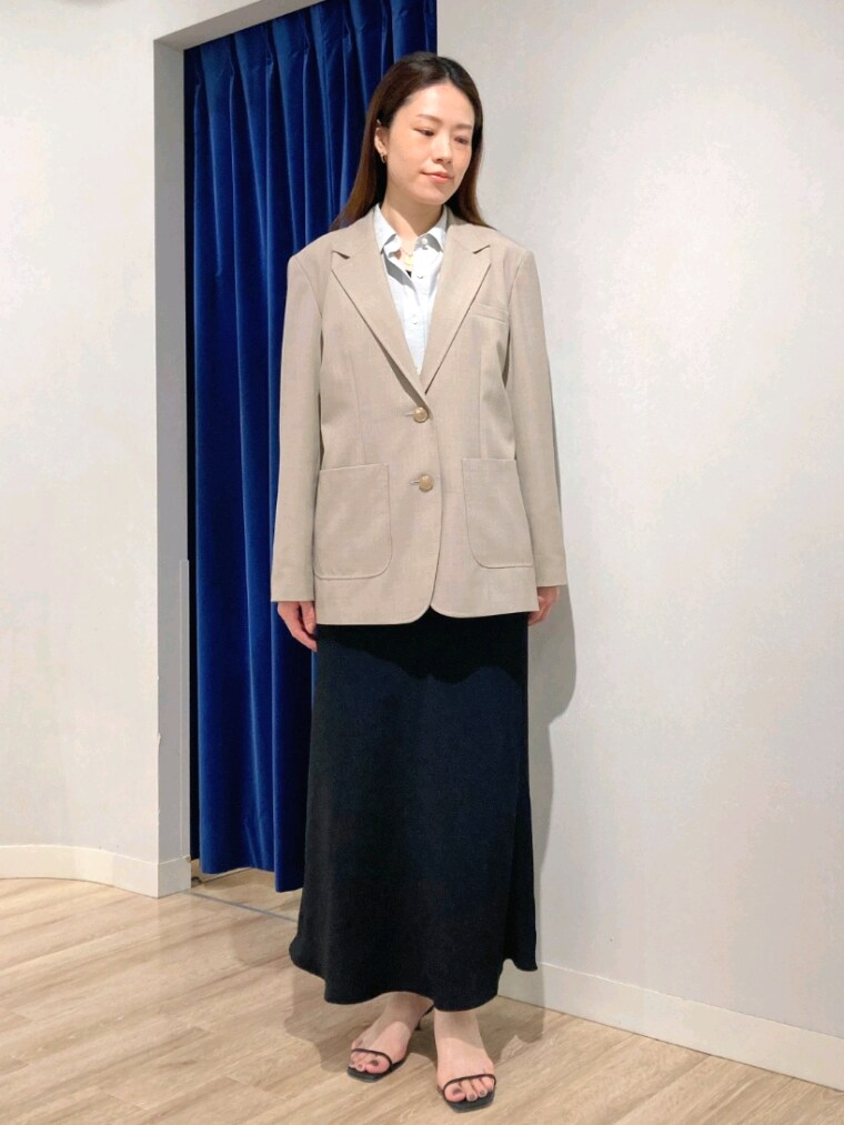 グリーン系のシャツ/ブラウス、ベージュ系のテーラードジャケット、ブラック系のスカートを着用したレディースの秋コーディネートの8枚目の写真