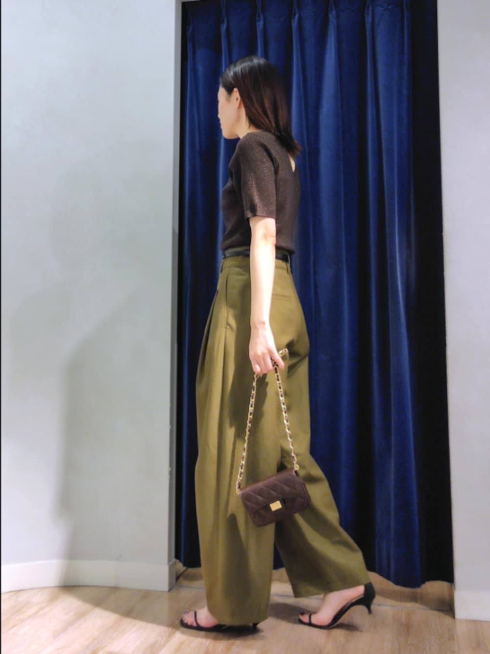 グリーン系のチノパンツ、ブラウン系のニット/セーター、ブラウン系のショルダーバッグを着用したレディースの秋コーディネートの6枚目の写真
