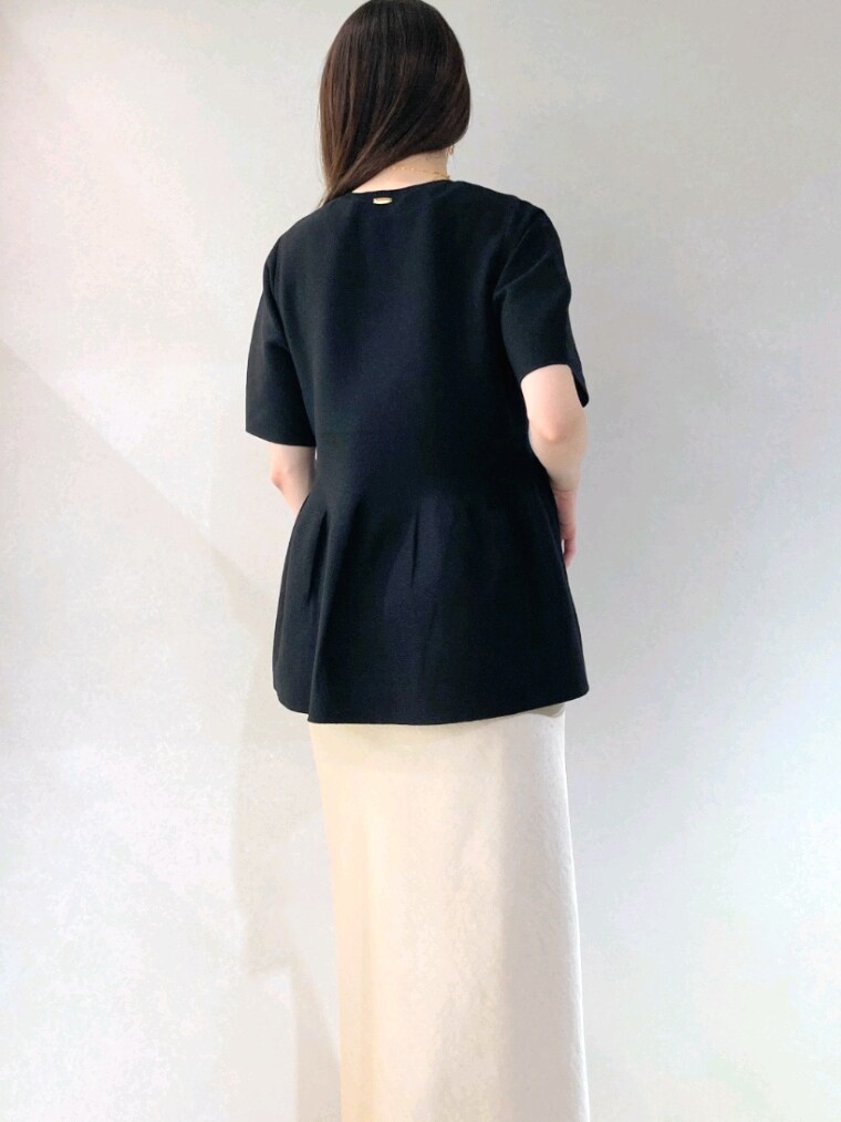 ブラック系のニット/セーター、ベージュ系のショルダーバッグ、ベージュ系のスカートを着用したレディースの春コーディネートの9枚目の写真