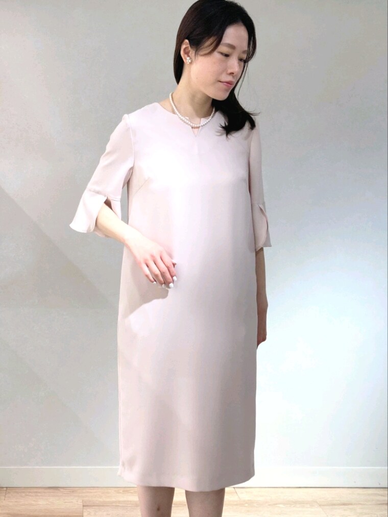 ピンク系のワンピース、ゴールド系のパンプス、ホワイト系のショルダーバッグを着用したレディースの春コーディネートの4枚目の写真