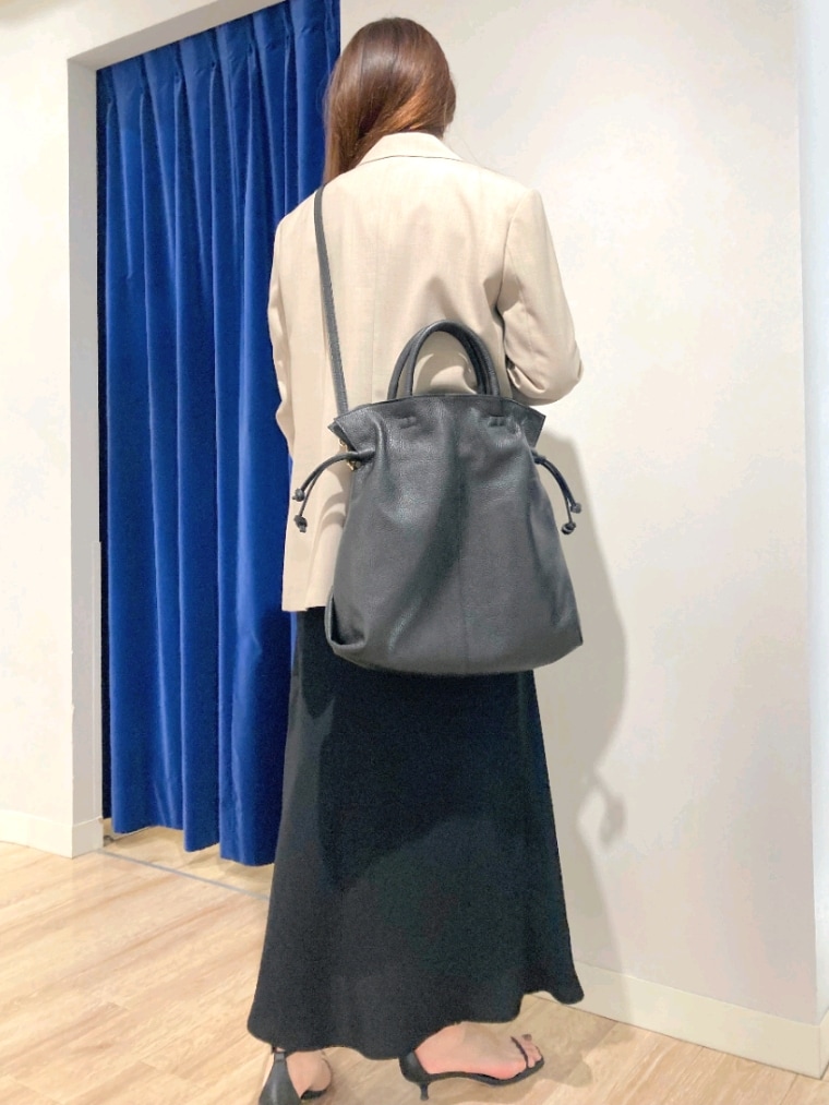 グリーン系のシャツ/ブラウス、ベージュ系のテーラードジャケット、ブラック系のスカートを着用したレディースの秋コーディネートの7枚目の写真