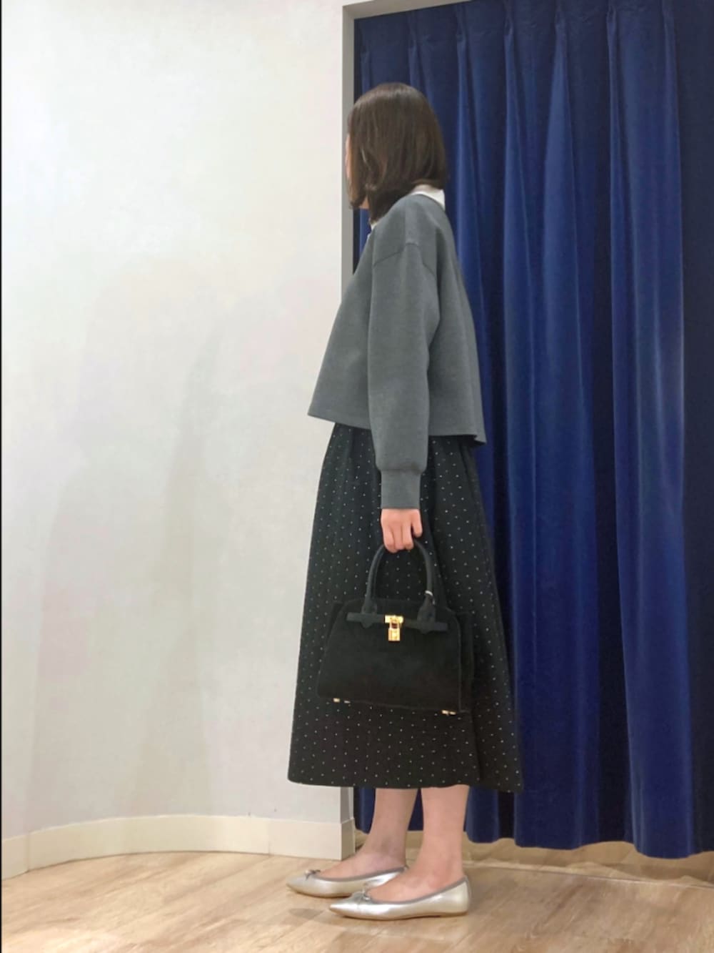 グレー系のTシャツ/カットソー、ブラック系のスカート、ブラック系のトートバッグを着用したレディースの秋コーディネートの5枚目の写真