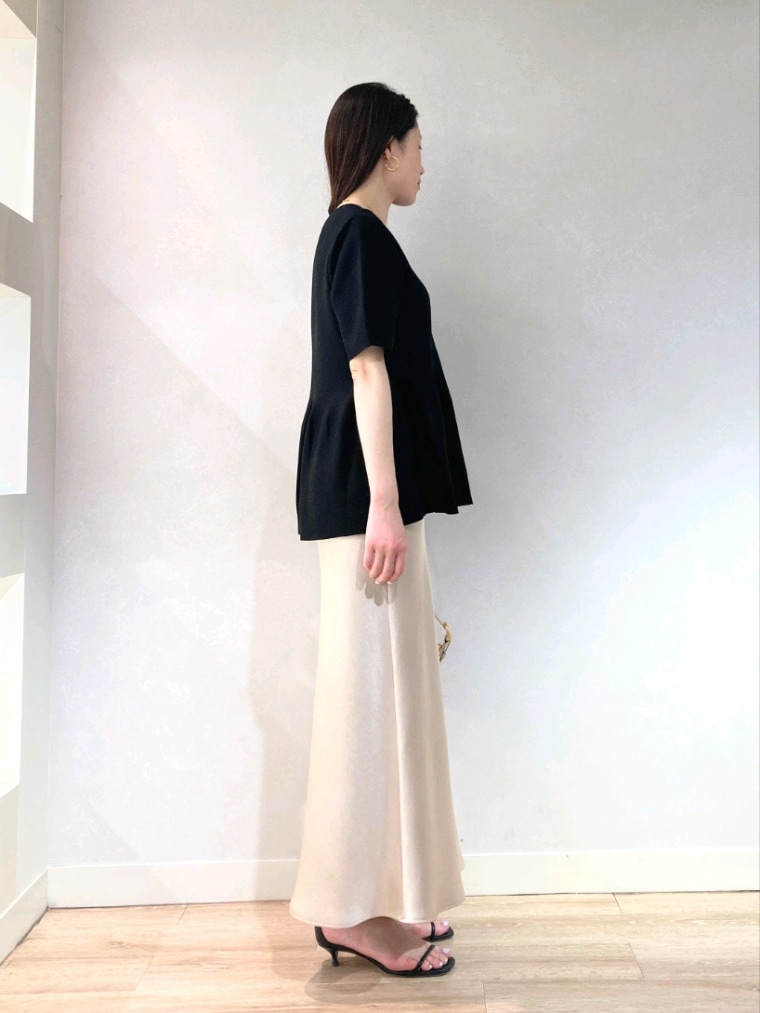 ブラック系のニット/セーター、ベージュ系のショルダーバッグ、ベージュ系のスカートを着用したレディースの春コーディネートの3枚目の写真