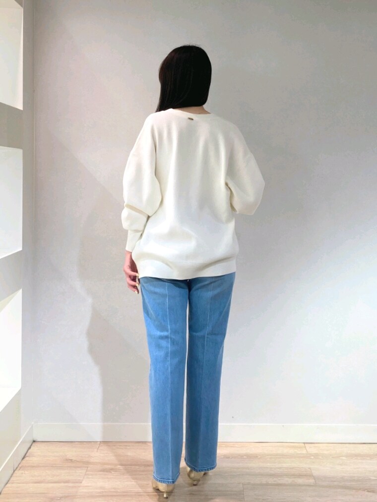 ホワイト系のニット/セーター、ゴールド系のキャミソール、ブルー系のデニムパンツを着用したレディースの春コーディネートの6枚目の写真