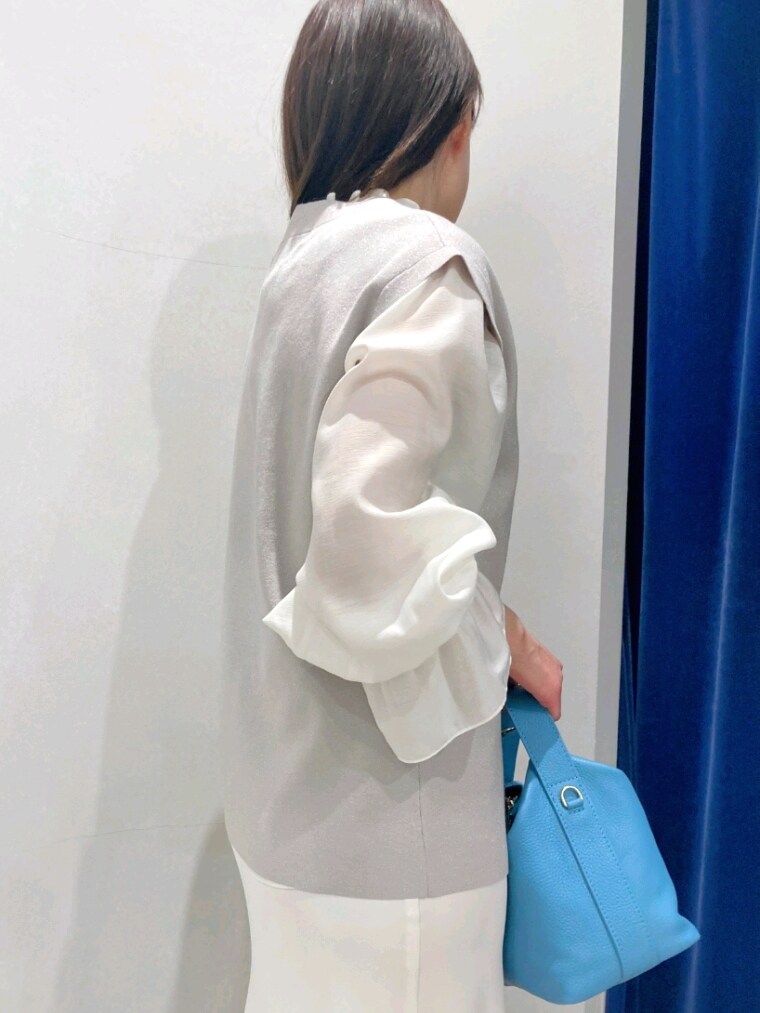 ホワイト系のシャツ/ブラウス、ベージュ系のニット/セーター、ホワイト系のスカートを着用したレディースの春コーディネートの7枚目の写真