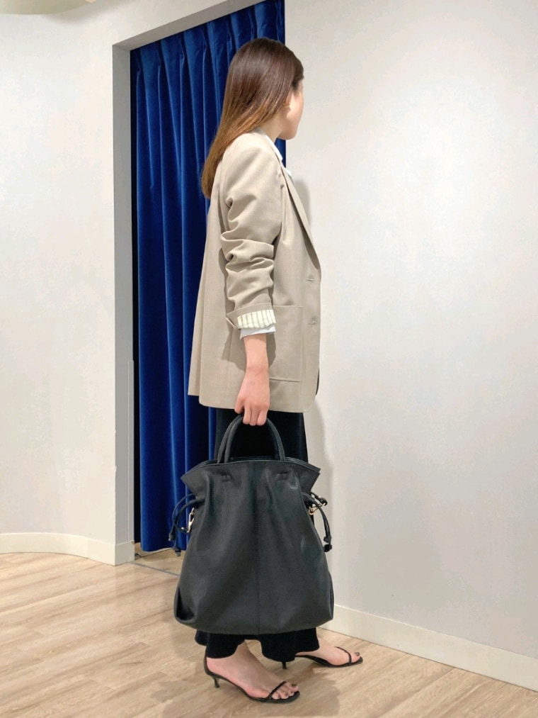 グリーン系のシャツ/ブラウス、ベージュ系のテーラードジャケット、ブラック系のスカートを着用したレディースの秋コーディネートの5枚目の写真