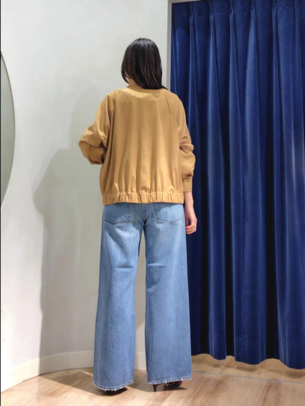 ブルー系のシャツ/ブラウス、イエロー系のブルゾン、ブルー系のデニムパンツを着用したレディースの秋コーディネートの6枚目の写真