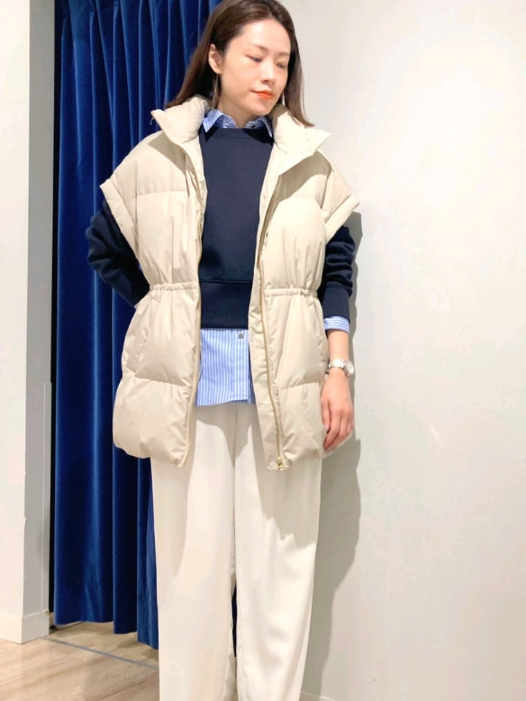 ブルー系のシャツ/ブラウス、ブルー系のTシャツ/カットソー、ベージュ系のダウンベストを着用したレディースの秋コーディネートの7枚目の写真