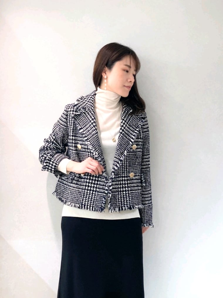 ブラック系のショルダーバッグ、ホワイト系のブーツ、ブラック系のスカートを着用したレディースの冬コーディネートの6枚目の写真