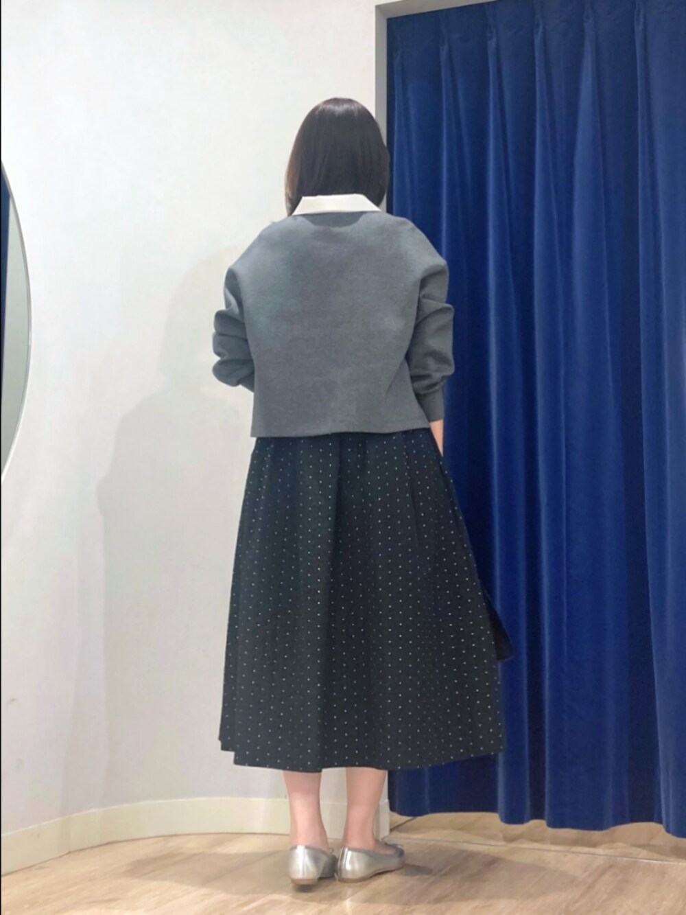 グレー系のTシャツ/カットソー、ブラック系のスカート、ブラック系のトートバッグを着用したレディースの秋コーディネートの4枚目の写真