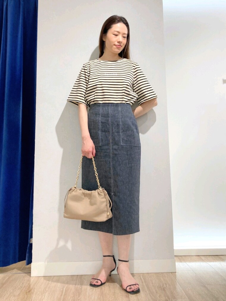 ベージュ系のTシャツ/カットソー、ブルー系のスカート、ベージュ系のショルダーバッグを着用したレディースの夏コーディネートの5枚目の写真