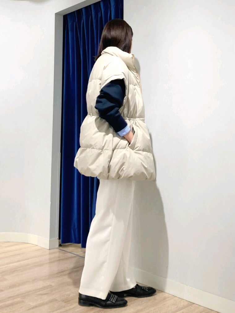 ブルー系のシャツ/ブラウス、ブルー系のTシャツ/カットソー、ベージュ系のダウンベストを着用したレディースの秋コーディネートの4枚目の写真