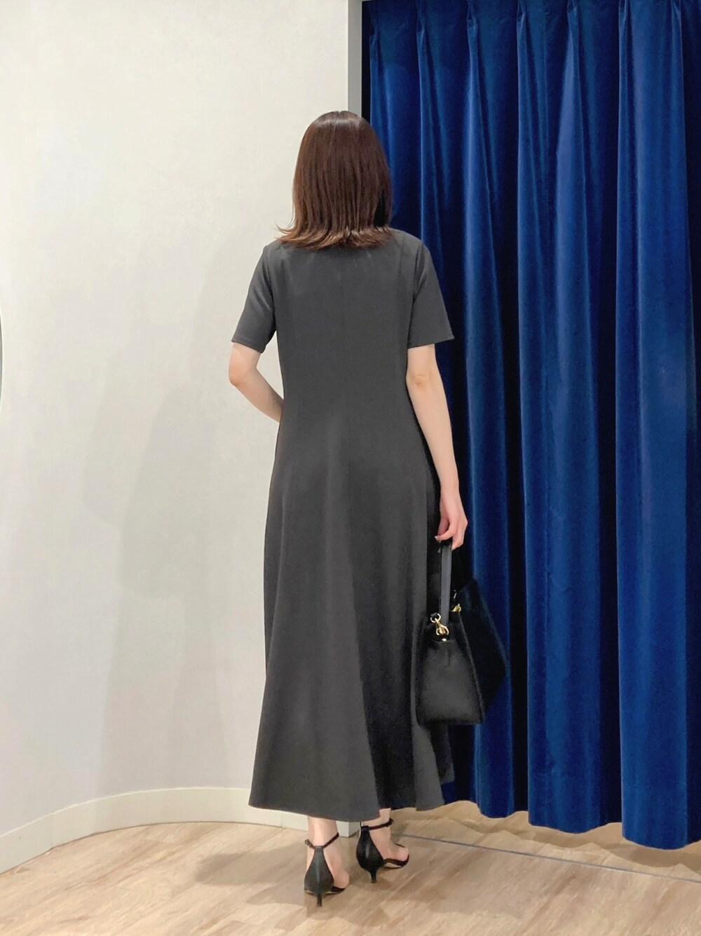 ベージュ系のテーラードジャケット、ブラック系のショルダーバッグ、グレー系のワンピースを着用したレディースの夏コーディネートの9枚目の写真