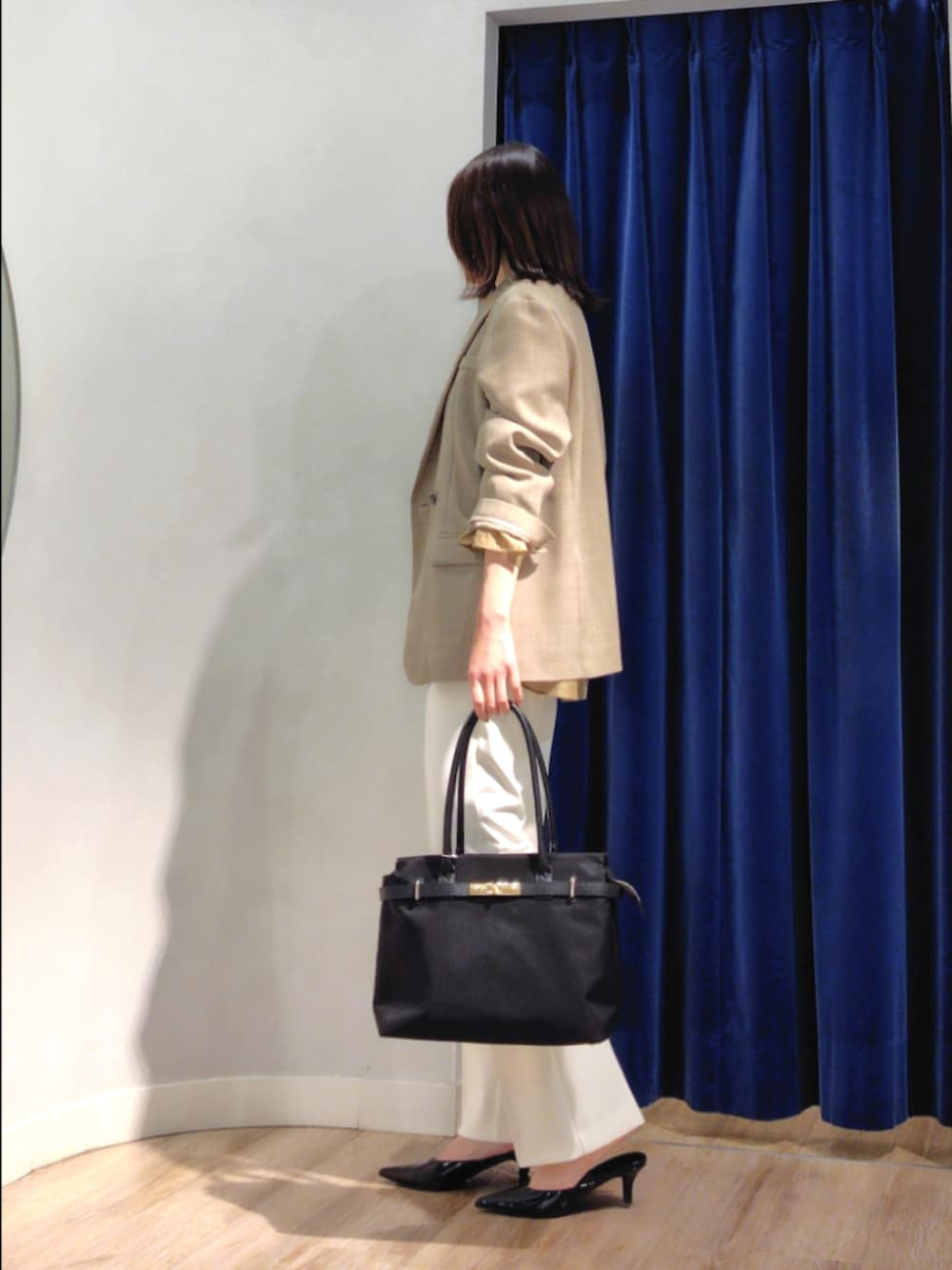 ベージュ系のテーラードジャケット、イエロー系のシャツ/ブラウス、ホワイト系のその他パンツを着用したレディースの春コーディネートの5枚目の写真