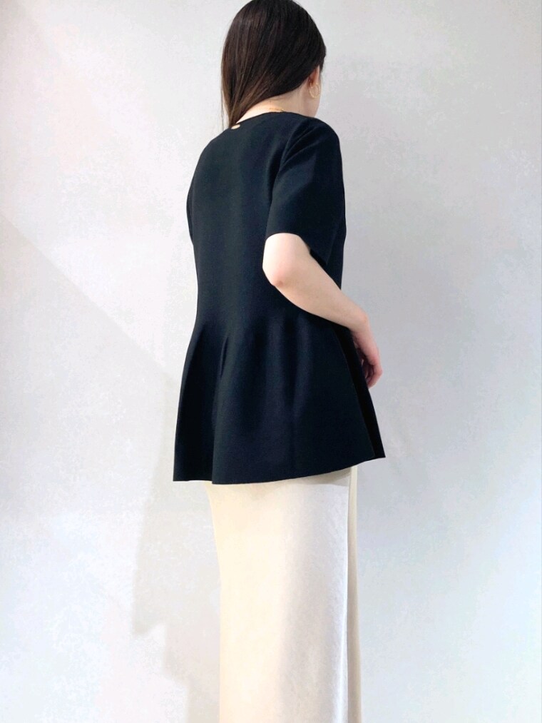 ブラック系のニット/セーター、ベージュ系のショルダーバッグ、ベージュ系のスカートを着用したレディースの春コーディネートの8枚目の写真