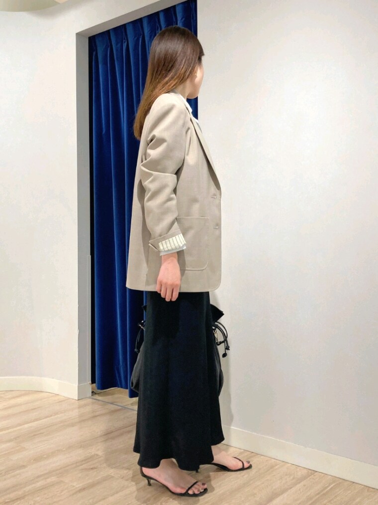 グリーン系のシャツ/ブラウス、ベージュ系のテーラードジャケット、ブラック系のスカートを着用したレディースの秋コーディネートの4枚目の写真