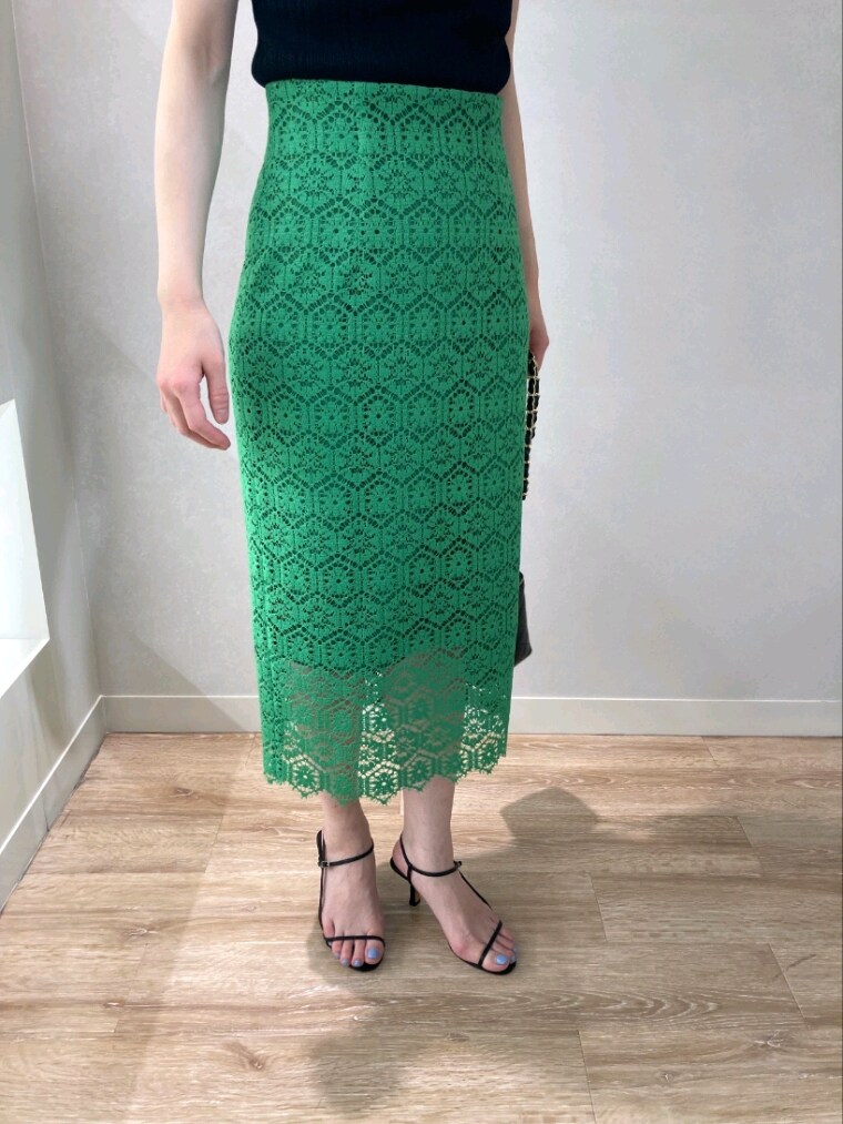 ブラック系のニット/セーター、グリーン系のスカート、ブラック系のサンダルを着用したレディースの春コーディネートの3枚目の写真