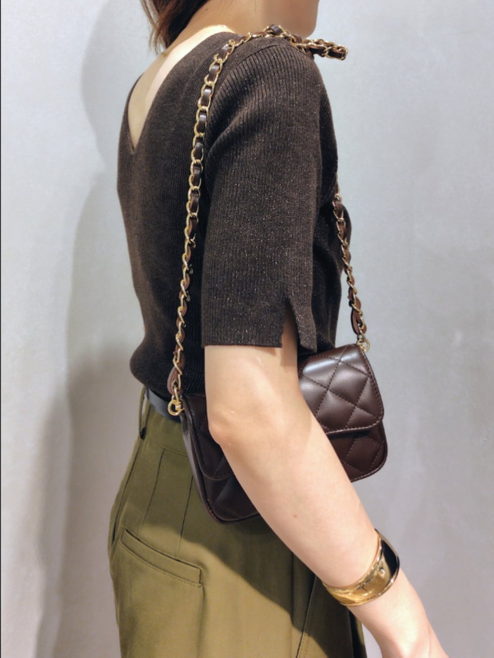 グリーン系のチノパンツ、ブラウン系のニット/セーター、ブラウン系のショルダーバッグを着用したレディースの秋コーディネートの8枚目の写真