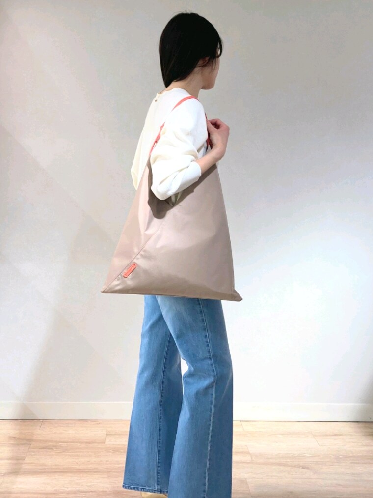ホワイト系のニット/セーター、ゴールド系のキャミソール、ブルー系のデニムパンツを着用したレディースの春コーディネートの9枚目の写真