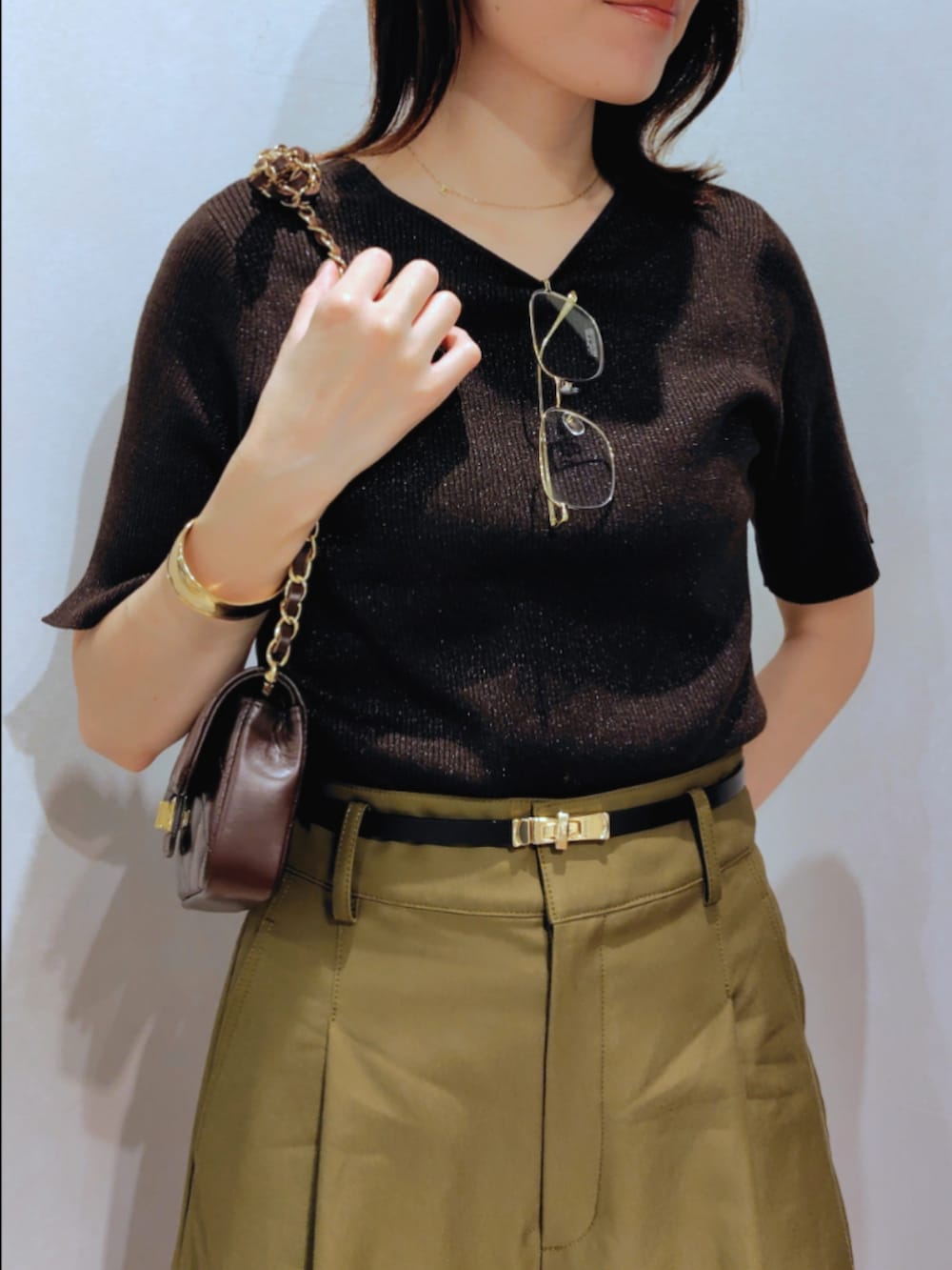 グリーン系のチノパンツ、ブラウン系のニット/セーター、ブラウン系のショルダーバッグを着用したレディースの秋コーディネートの7枚目の写真