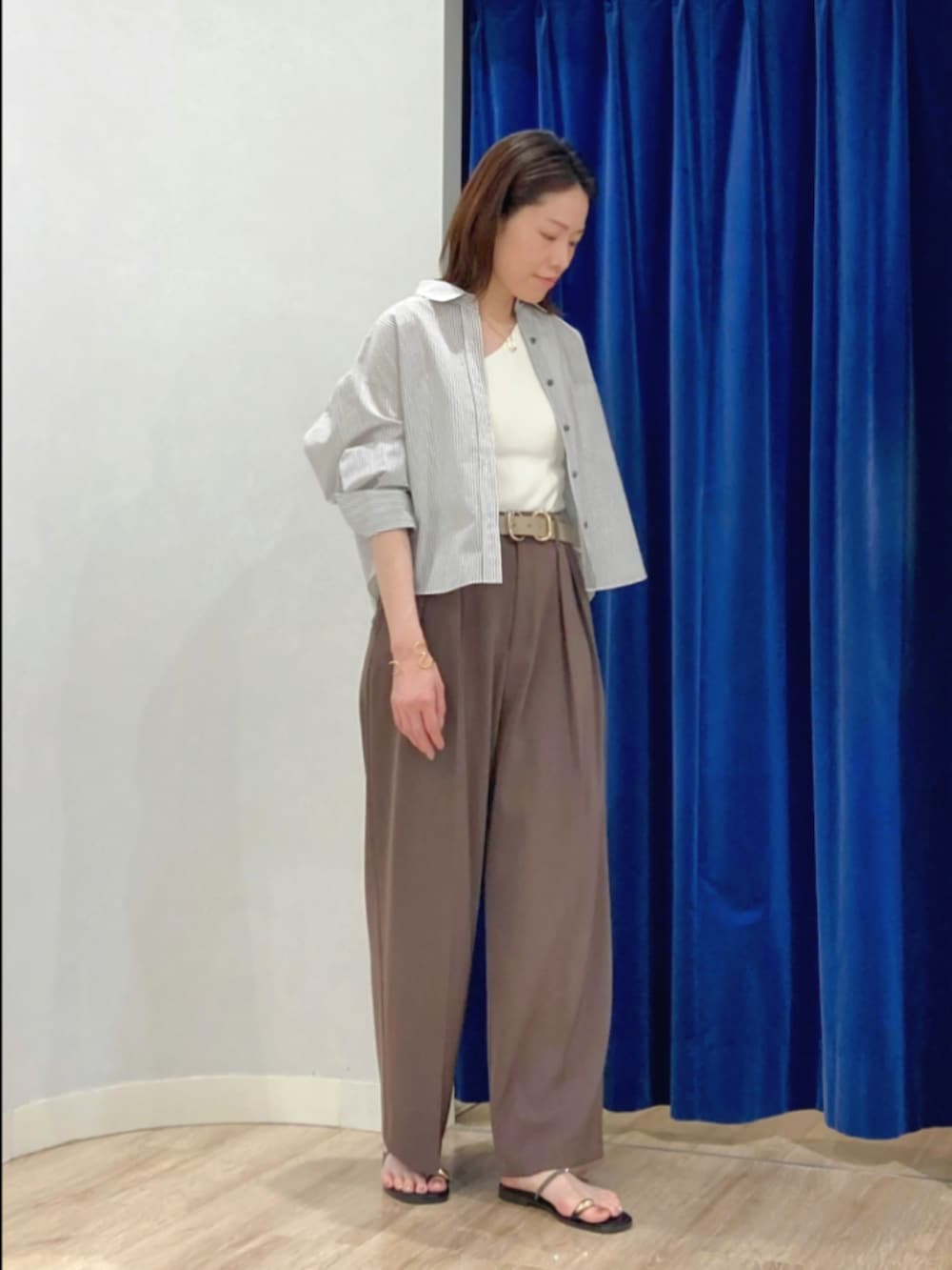 ブラウン系のその他パンツ、ゴールド系のサンダル、ベージュ系のシャツ/ブラウスを着用したレディースの夏コーディネートの2枚目の写真
