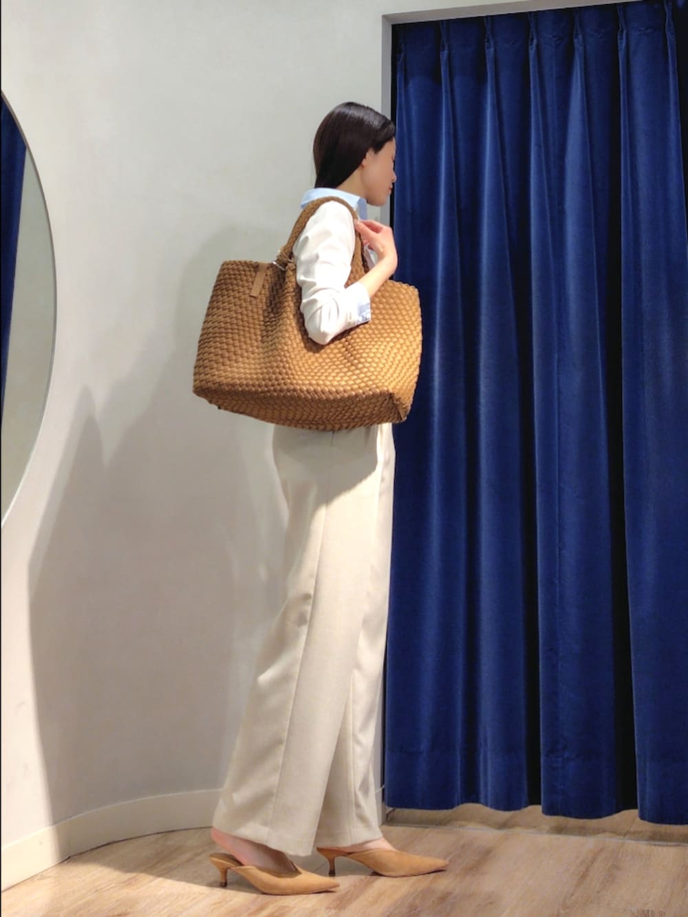 ブラウン系のトートバッグ、ベージュ系のその他パンツ、ホワイト系のニット/セーターを着用したレディースの春コーディネートの4枚目の写真