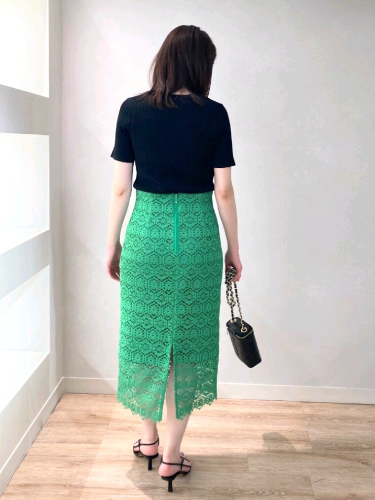ブラック系のニット/セーター、グリーン系のスカート、ブラック系のサンダルを着用したレディースの春コーディネートの5枚目の写真