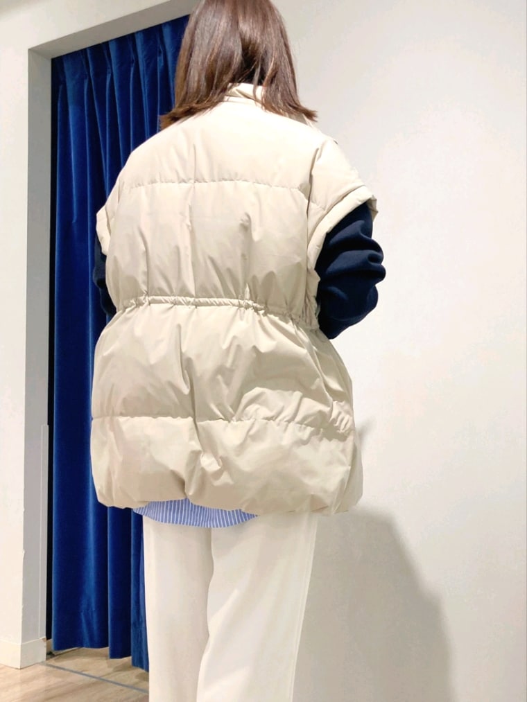 ブルー系のシャツ/ブラウス、ブルー系のTシャツ/カットソー、ベージュ系のダウンベストを着用したレディースの秋コーディネートの9枚目の写真