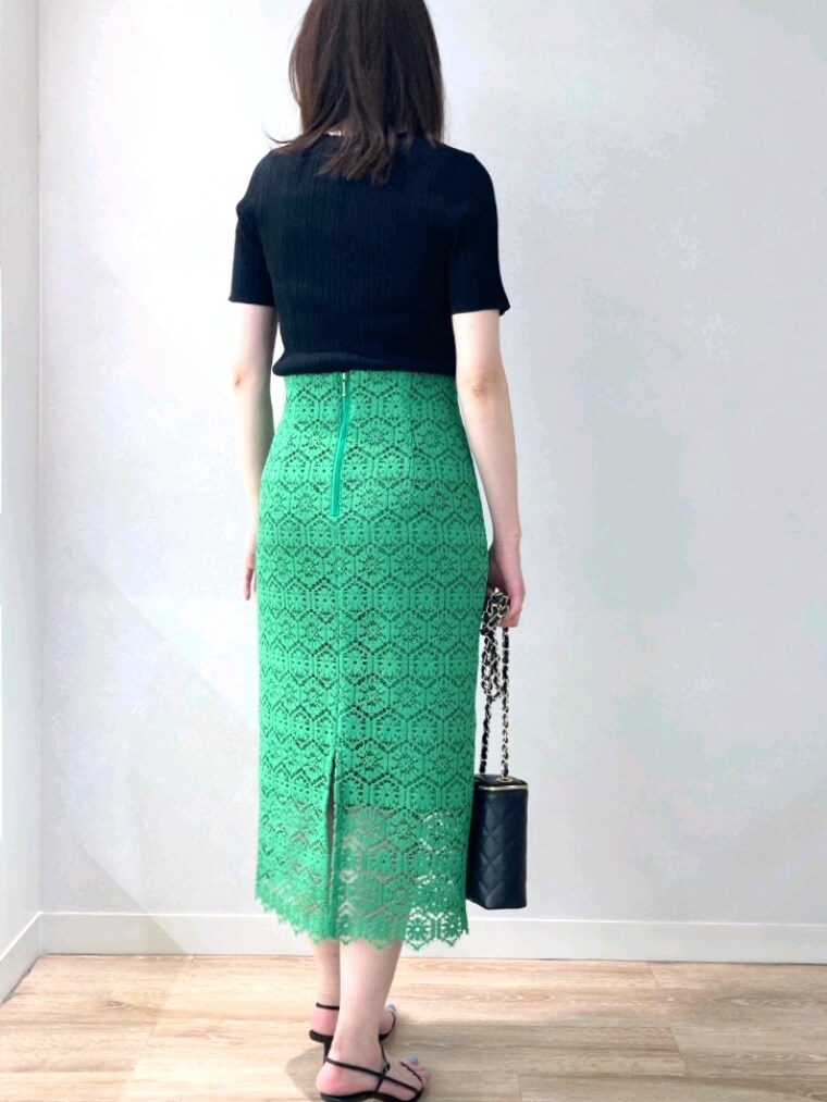 ブラック系のニット/セーター、グリーン系のスカート、ブラック系のサンダルを着用したレディースの春コーディネートの4枚目の写真