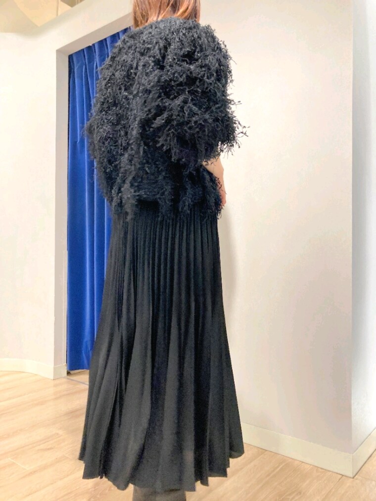 ブラック系のニット/セーター、グレー系のバッグ、ホワイト系のダウンジャケット/コートを着用したレディースの秋コーディネートの7枚目の写真