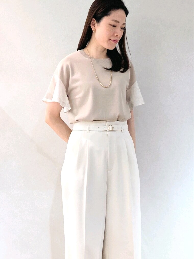 ベージュ系のニット/セーター、ブラック系のトートバッグ、ゴールド系のネックレスを着用したレディースの夏コーディネートの6枚目の写真