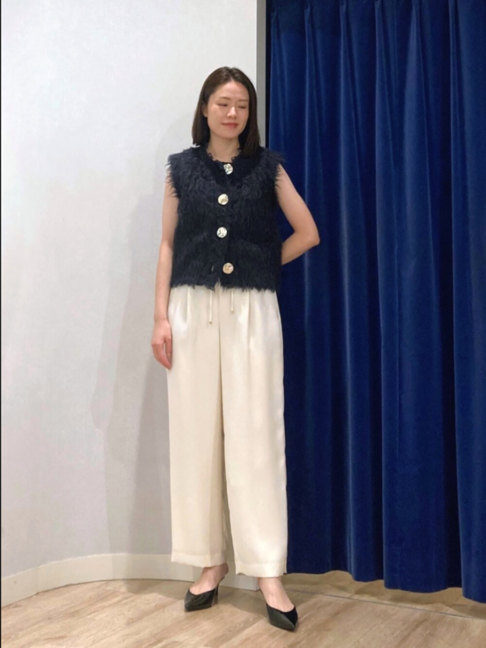 ブルー系のベスト、ブラック系のタンクトップ、ブラウン系のその他パンツを着用したレディースの秋コーディネートの10枚目の写真