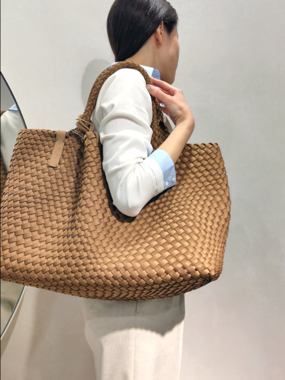 ブラウン系のトートバッグ、ベージュ系のその他パンツ、ホワイト系のニット/セーターを着用したレディースの春コーディネートの6枚目の写真