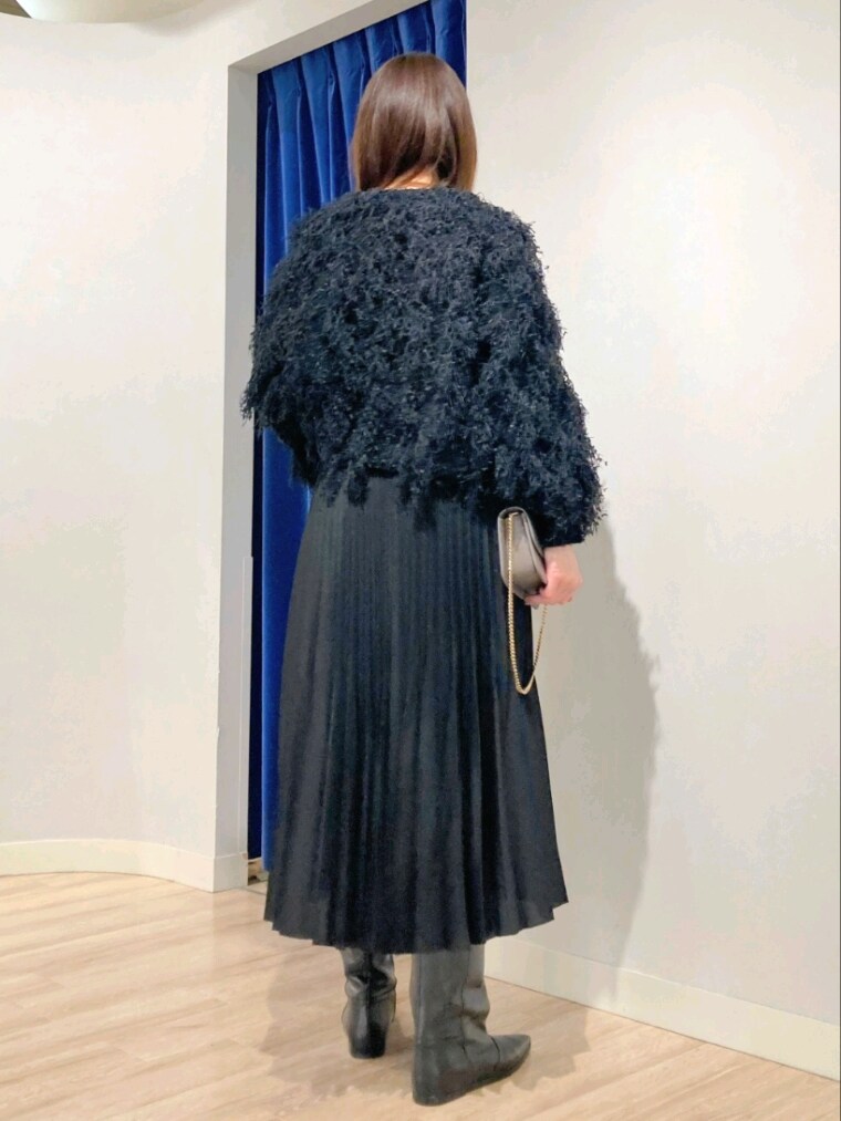 ブラック系のニット/セーター、グレー系のバッグ、ホワイト系のダウンジャケット/コートを着用したレディースの秋コーディネートの5枚目の写真