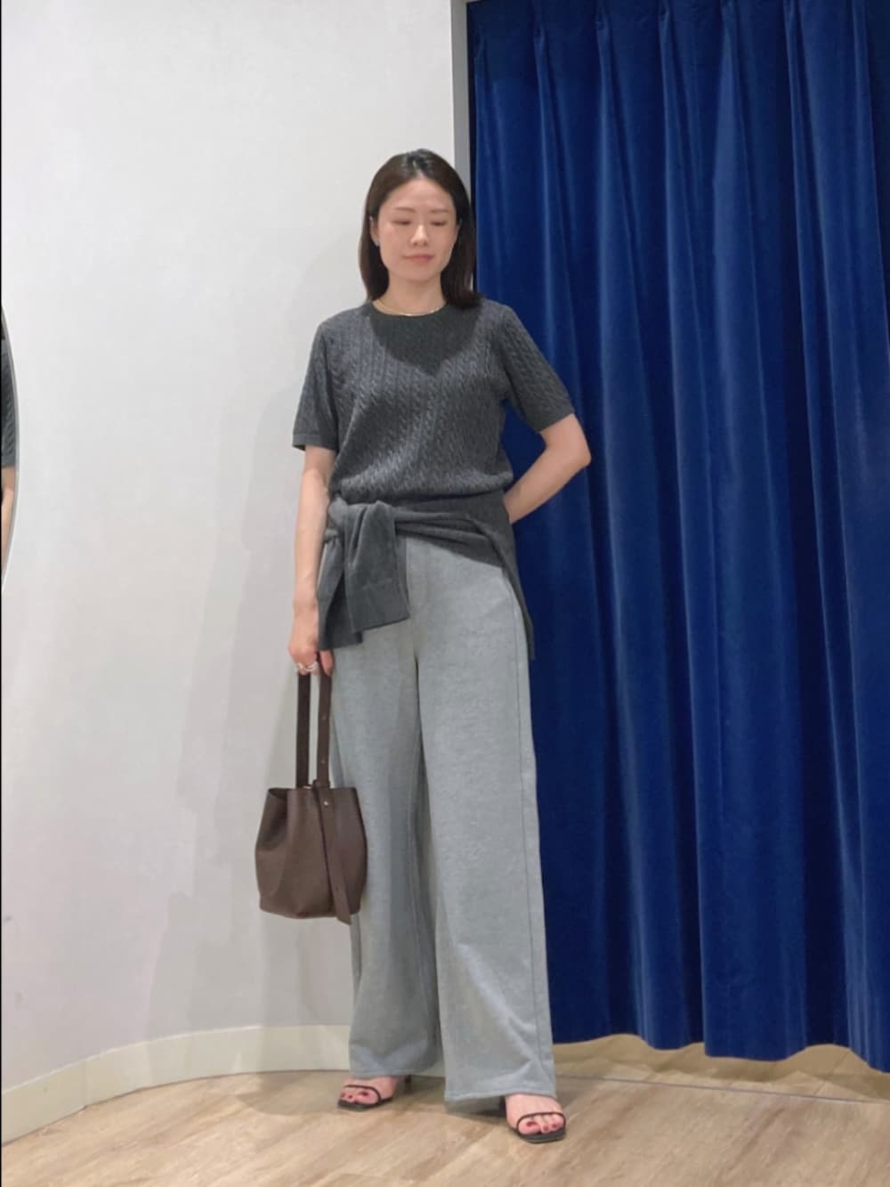 グレー系のニット/セーター、グレー系のカーディガン/ボレロ、グレー系のパンツを着用したレディースの秋コーディネートの2枚目の写真
