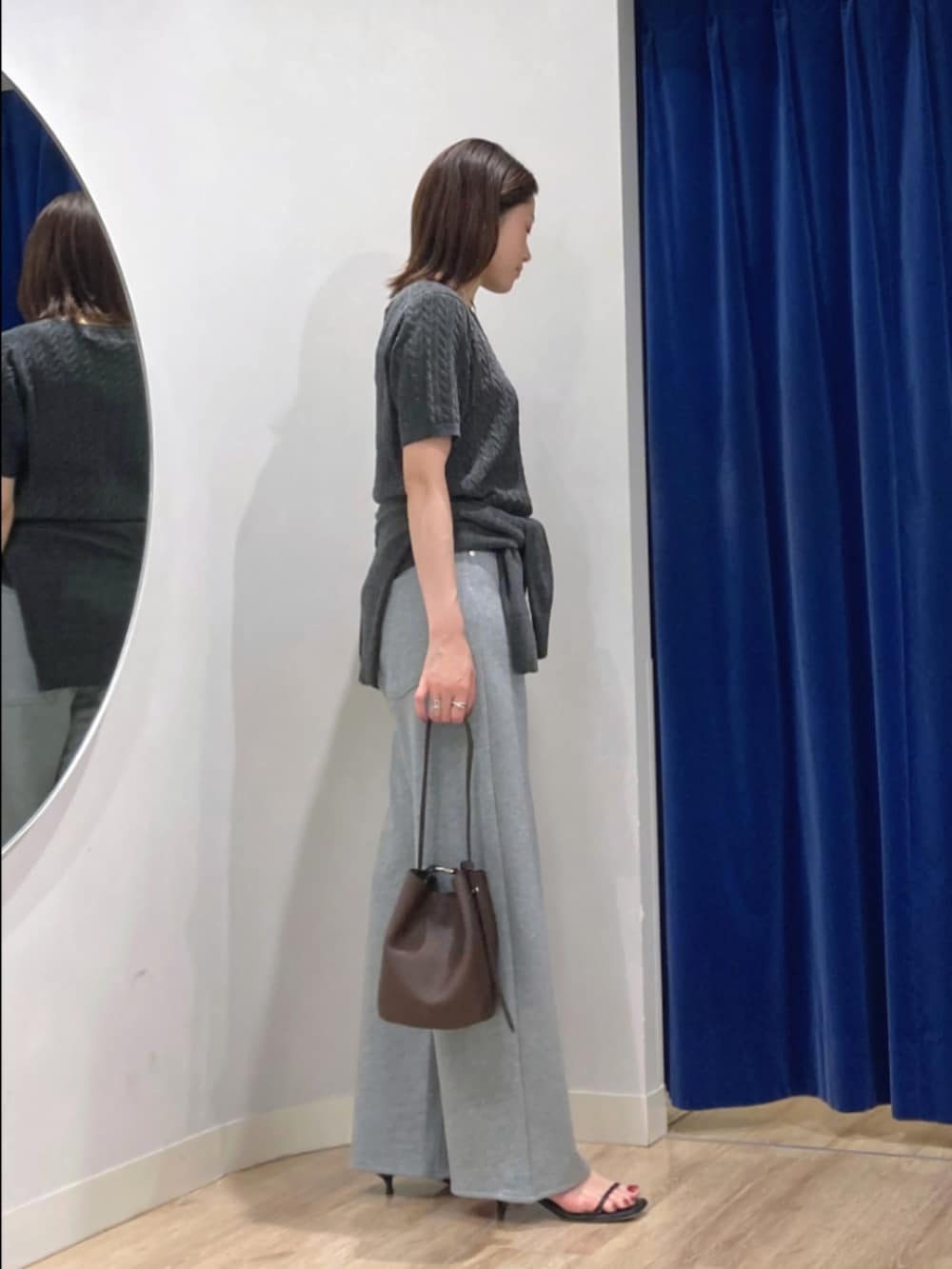 グレー系のニット/セーター、グレー系のカーディガン/ボレロ、グレー系のパンツを着用したレディースの秋コーディネートの3枚目の写真