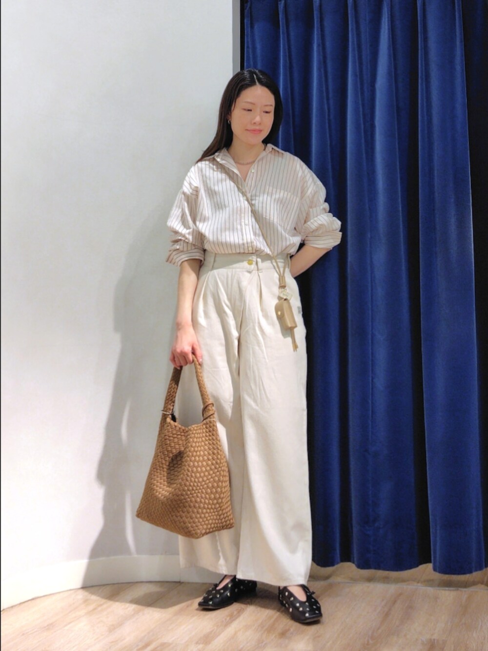 ブルー系のシャツ/ブラウス、ホワイト系のその他パンツ、ブラウン系のショルダーバッグを着用したレディースの春コーディネートの2枚目の写真