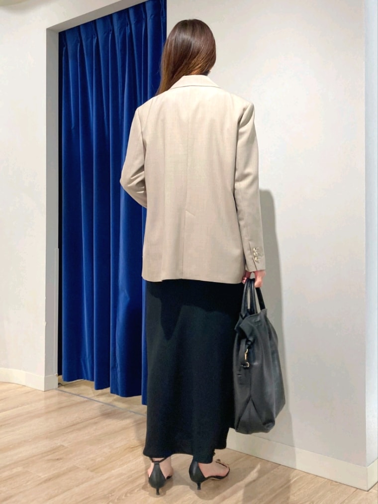 グリーン系のシャツ/ブラウス、ベージュ系のテーラードジャケット、ブラック系のスカートを着用したレディースの秋コーディネートの6枚目の写真