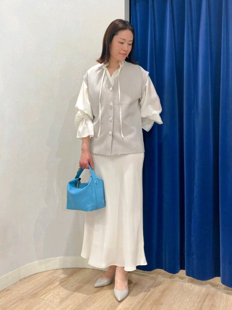 ホワイト系のシャツ/ブラウス、ベージュ系のニット/セーター、ホワイト系のスカートを着用したレディースの春コーディネートの2枚目の写真