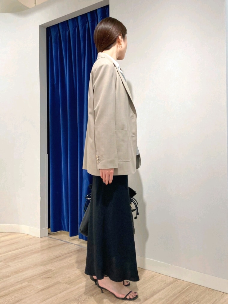 グリーン系のシャツ/ブラウス、ベージュ系のテーラードジャケット、ブラック系のスカートを着用したレディースの秋コーディネートの3枚目の写真