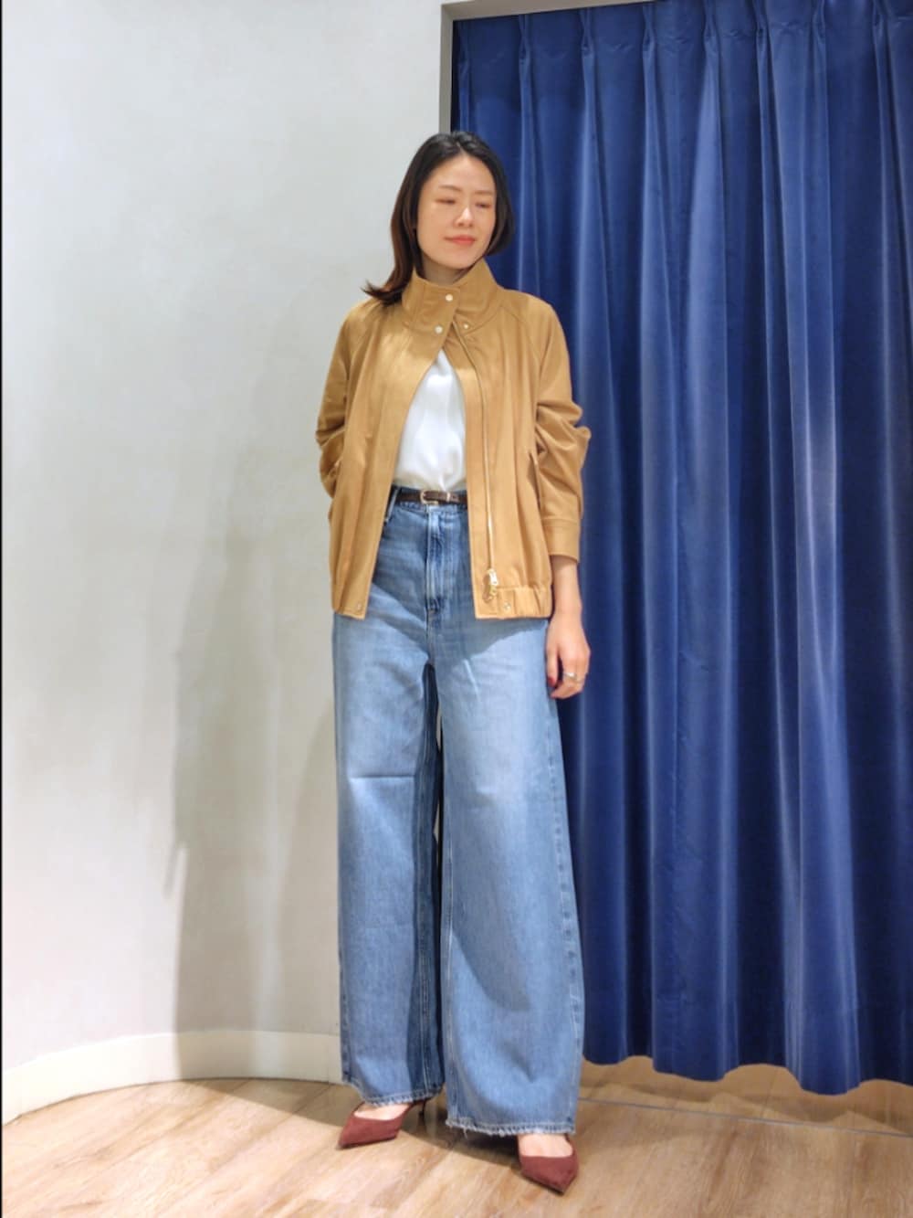 ブルー系のシャツ/ブラウス、イエロー系のブルゾン、ブルー系のデニムパンツを着用したレディースの秋コーディネートの2枚目の写真