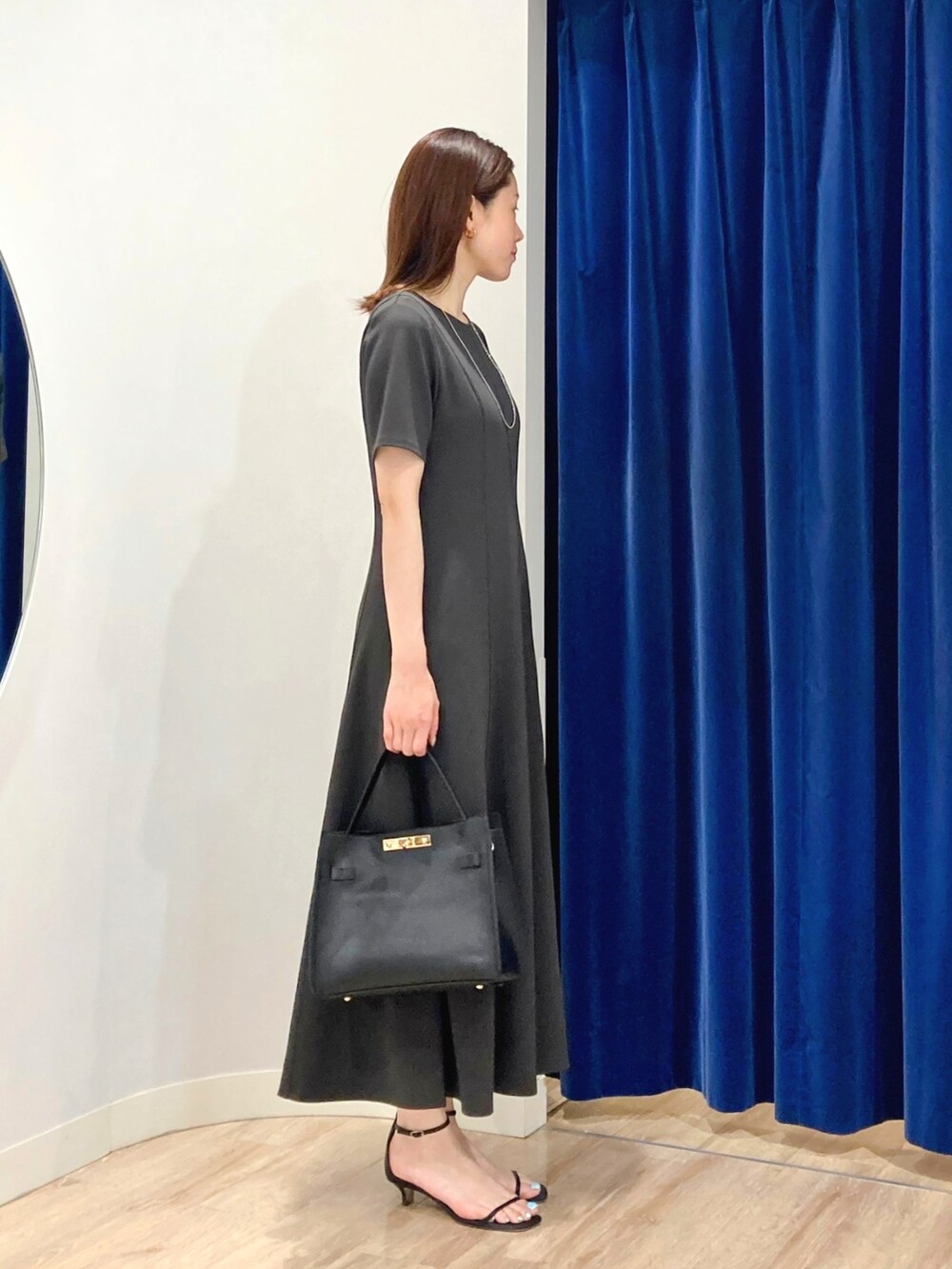 ベージュ系のテーラードジャケット、ブラック系のショルダーバッグ、グレー系のワンピースを着用したレディースの夏コーディネートの8枚目の写真