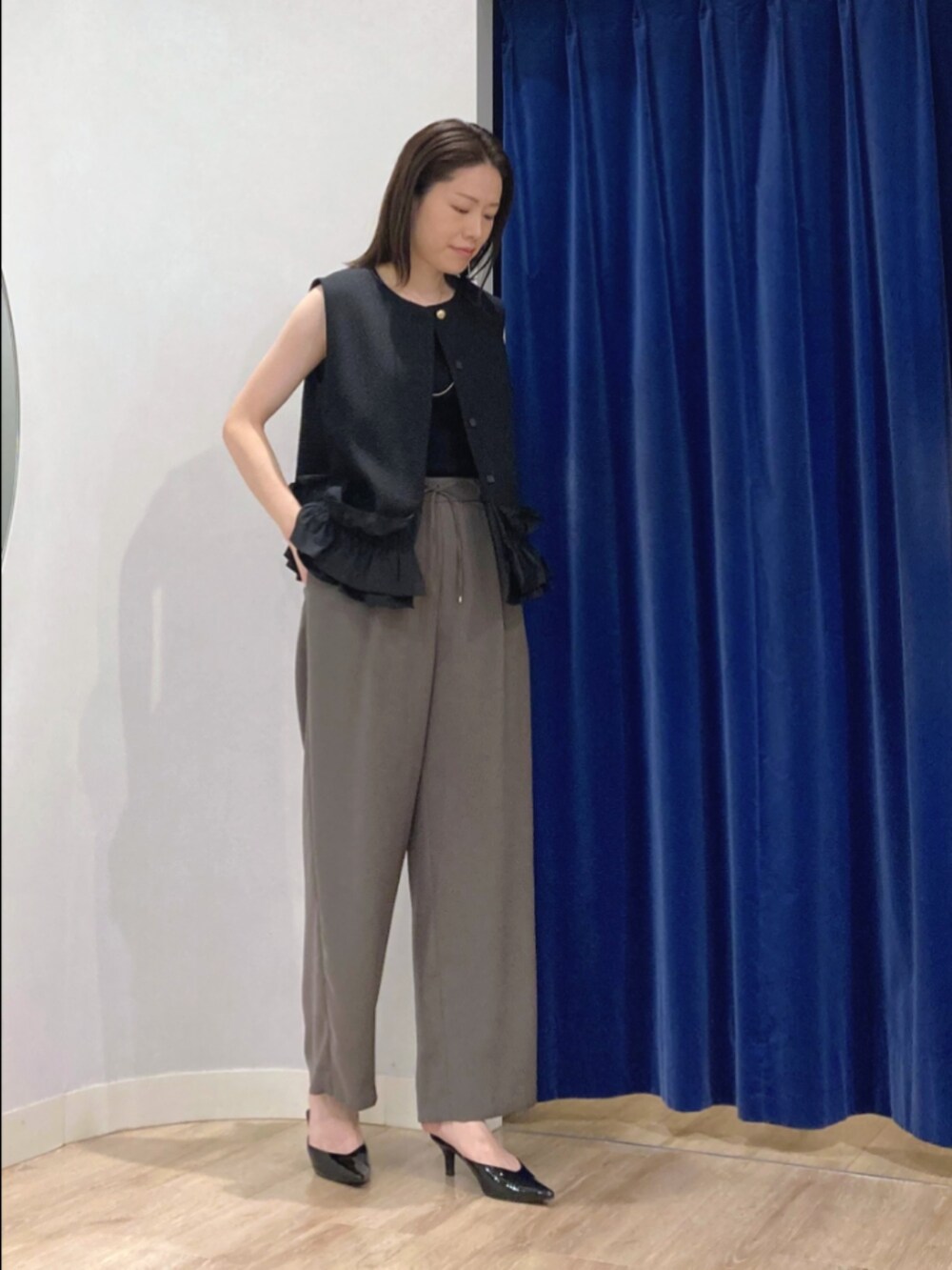 ブラック系のベスト、ブラウン系のその他パンツ、シルバー系のネックレスを着用したレディースの秋コーディネートの3枚目の写真