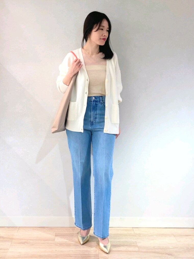 ホワイト系のニット/セーター、ゴールド系のキャミソール、ブルー系のデニムパンツを着用したレディースの春コーディネートの2枚目の写真
