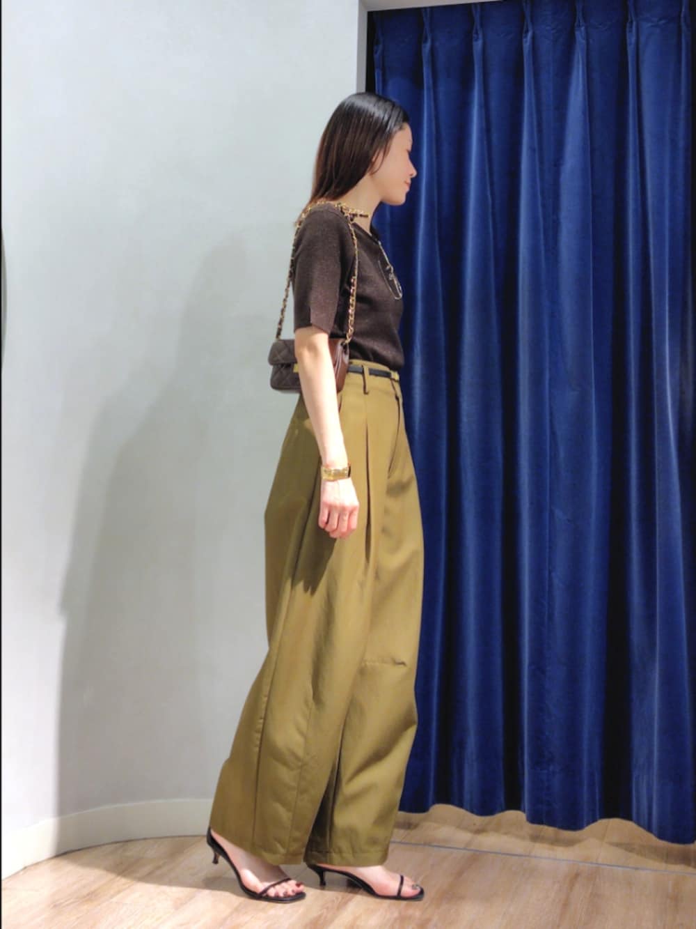 グリーン系のチノパンツ、ブラウン系のニット/セーター、ブラウン系のショルダーバッグを着用したレディースの秋コーディネートの4枚目の写真