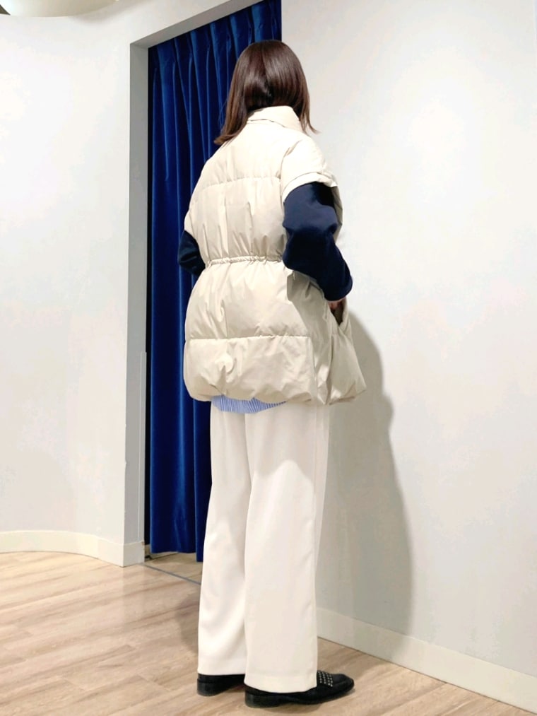 ブルー系のシャツ/ブラウス、ブルー系のTシャツ/カットソー、ベージュ系のダウンベストを着用したレディースの秋コーディネートの5枚目の写真